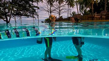 An underwater view of a swimming pool with the words "atmosphere resorts" and "philippines" visible on the pool's surface.