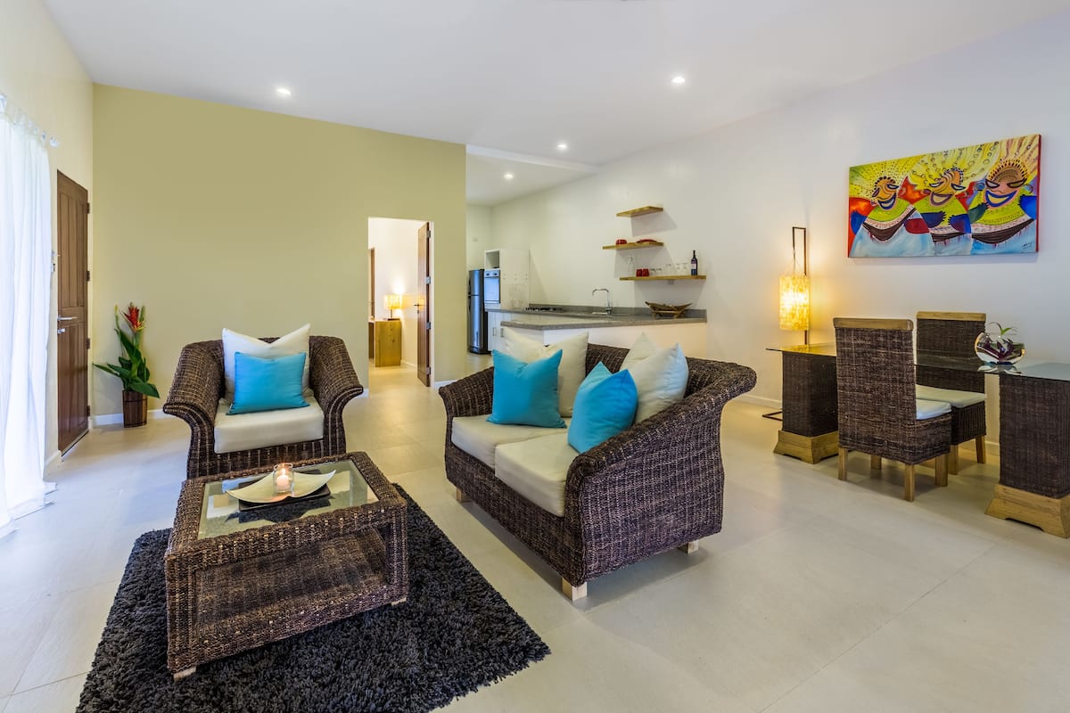 A living room with two sofas, a coffee table, and a dining area with chairs and a table.