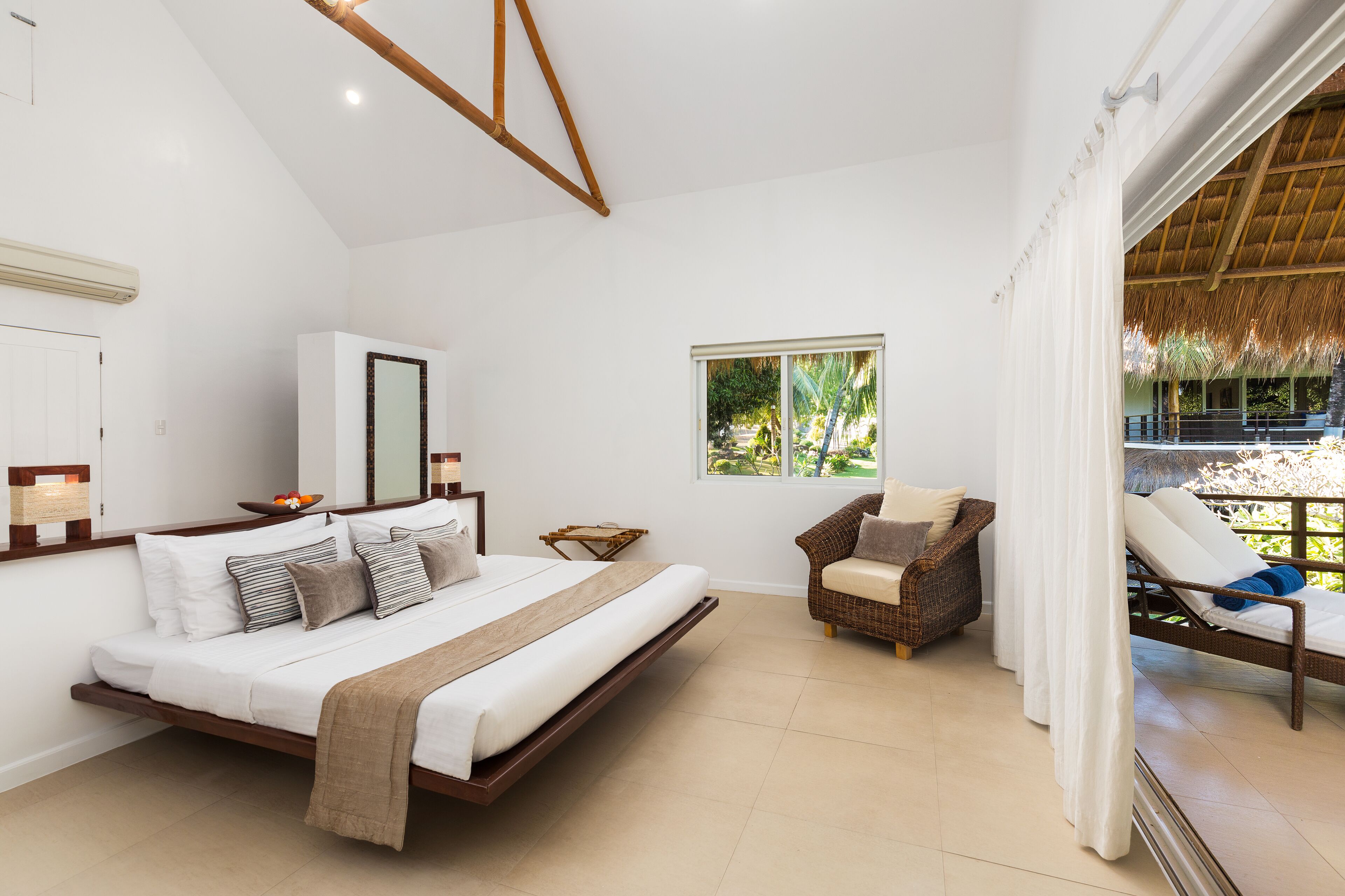 Une chambre à coucher avec un lit, une chaise, une fenêtre et une vue sur l’extérieur.