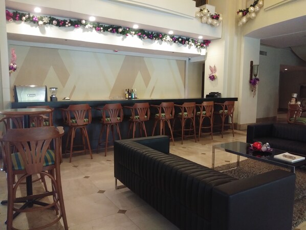 A lobby with a bar area, seating arrangements, and a reception desk. - The Mansion (Iloilo)