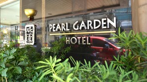 The exterior of the Pearl Garden Hotel with a sign indicating its name. - Pearl Garden Hotel (Manila)