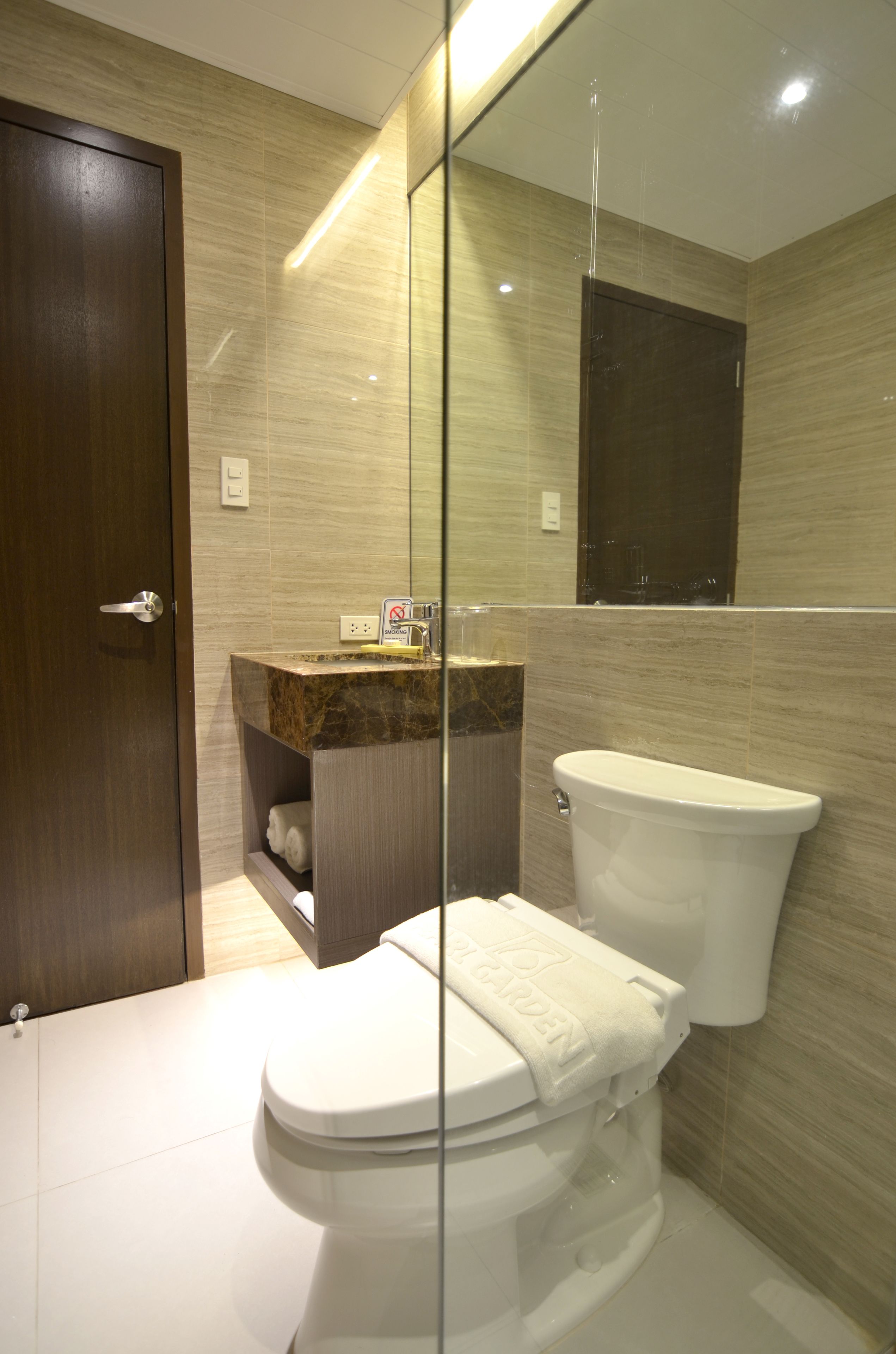 Ein modernes Badezimmer mit Toilette, Waschbecken und Duschkabine aus Glas.