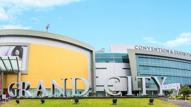 Um edifício com uma grande placa com a inscrição "GRAND CITY" e outra placa acima indicando "CONVEÇÃO & EXPOSIÇÃO".