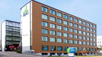 A Holiday Inn Express hotel with a modern design, featuring a large number of windows and a prominent sign.