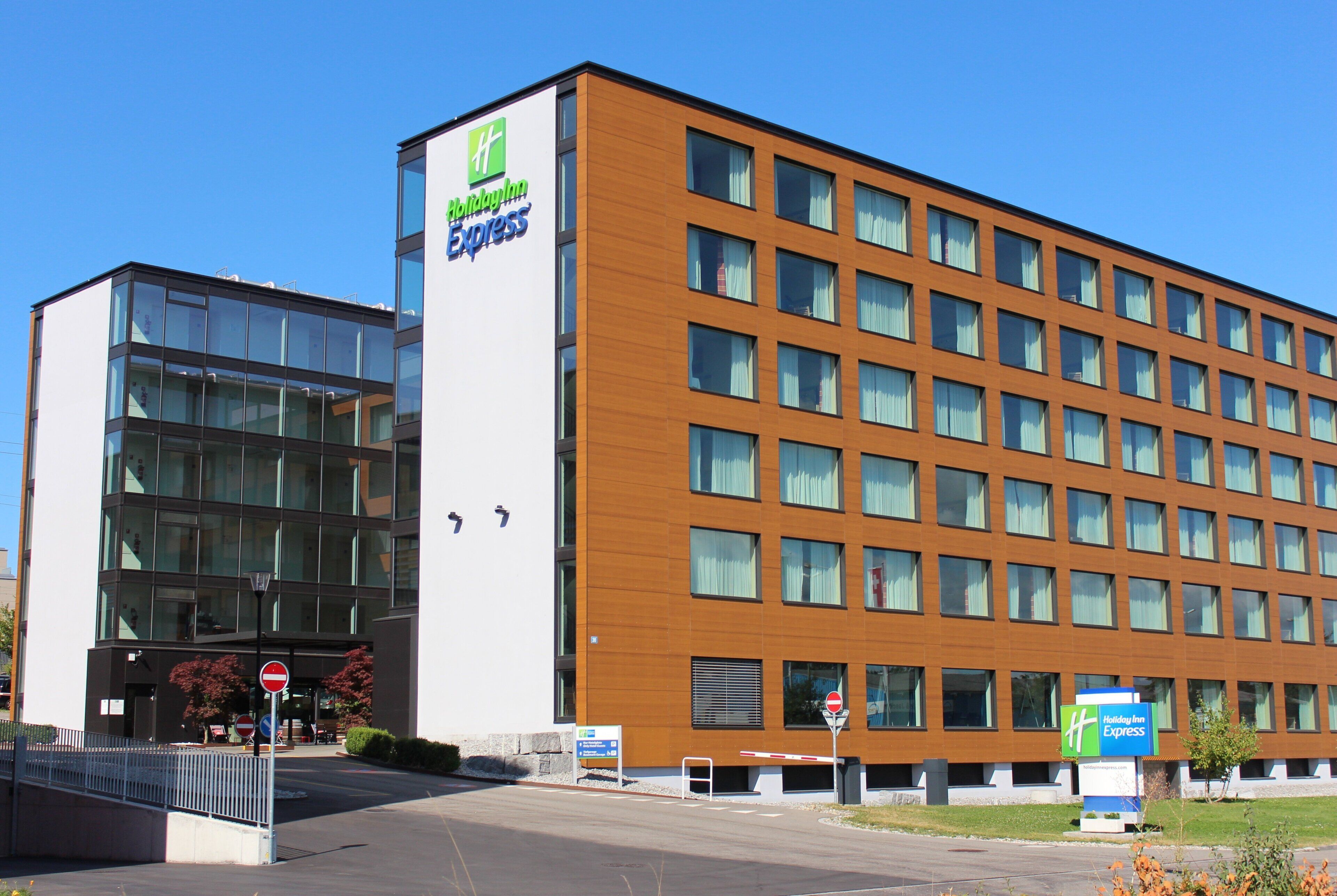A Holiday Inn Express hotel with a modern design, featuring a large glass facade and a brick exterior.