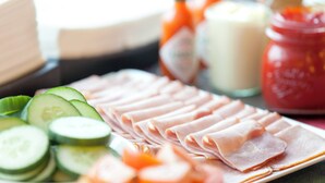 A plate of sliced ham and cucumber slices on a table. - Holiday Inn Express Zurich Airport by IHG (Ruemlang)