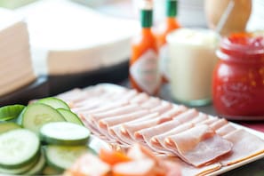 A plate of sliced ham and cucumber slices on a table. - Holiday Inn Express Zurich Airport by IHG (Ruemlang)