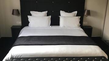 A neatly made bed with a black headboard and white bedding.