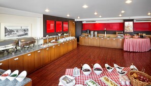 A buffet setup with various food items and a checkered tablecloth.