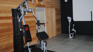 Un gimnasio con equipo de ejercicio, una pared de madera y una pantalla de proyector.