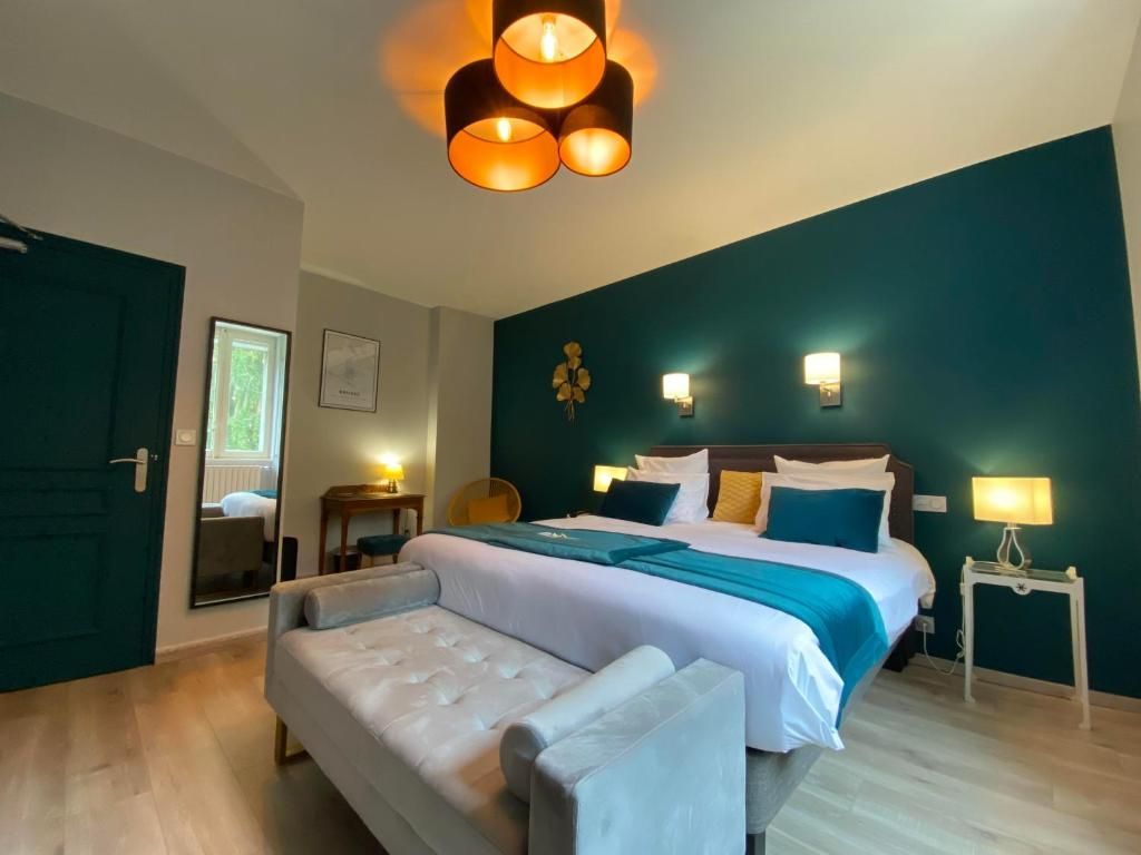 A hotel room with a large bed, a sitting area, and a desk.