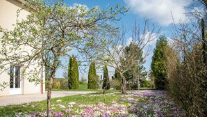 A garden with blooming flowers and trees in front of a building. - Logis De France Des Sources (Creney-pres-Troyes)