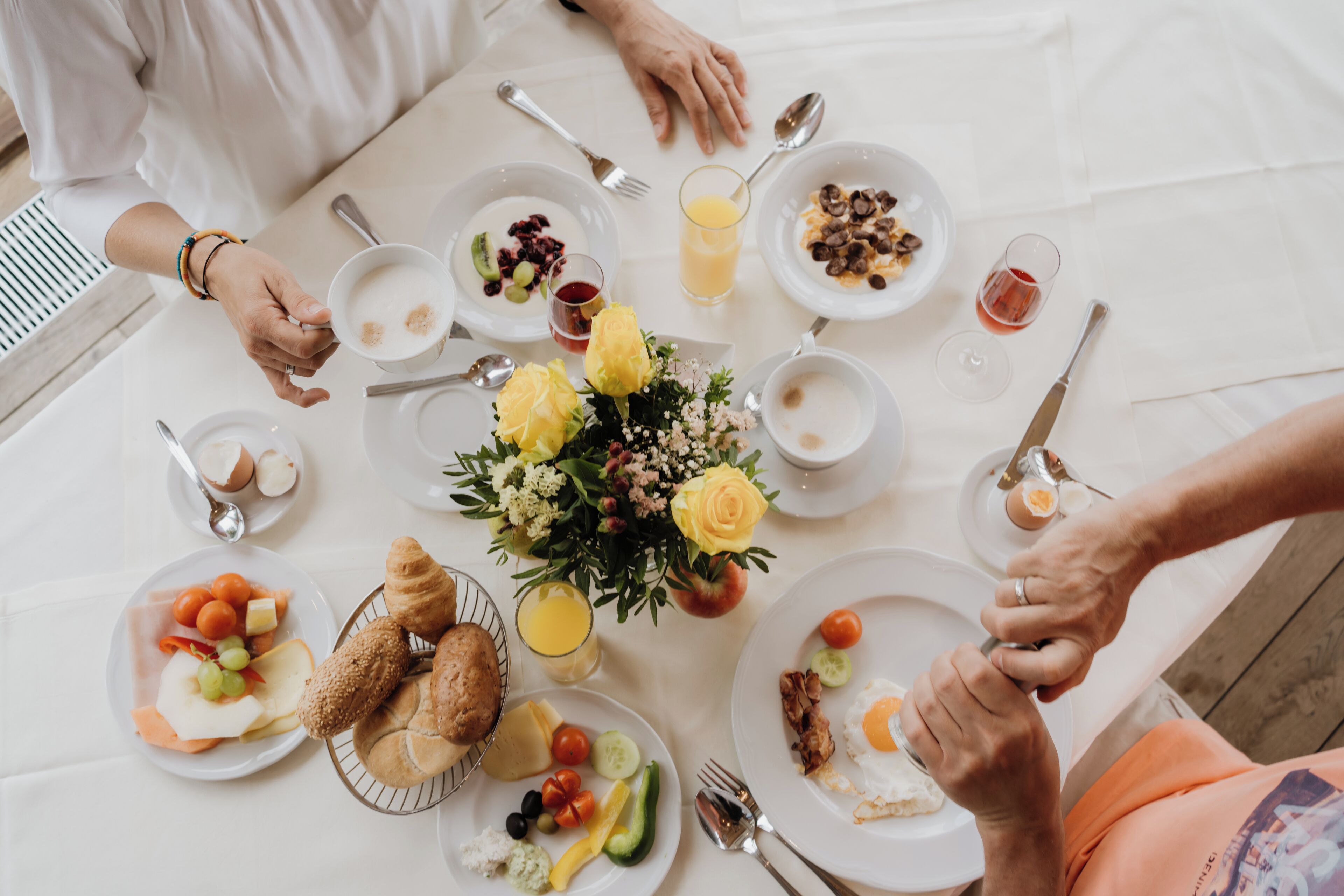 A breakfast setting with various dishes, including fruits, eggs, and pastries, arranged on a table.
