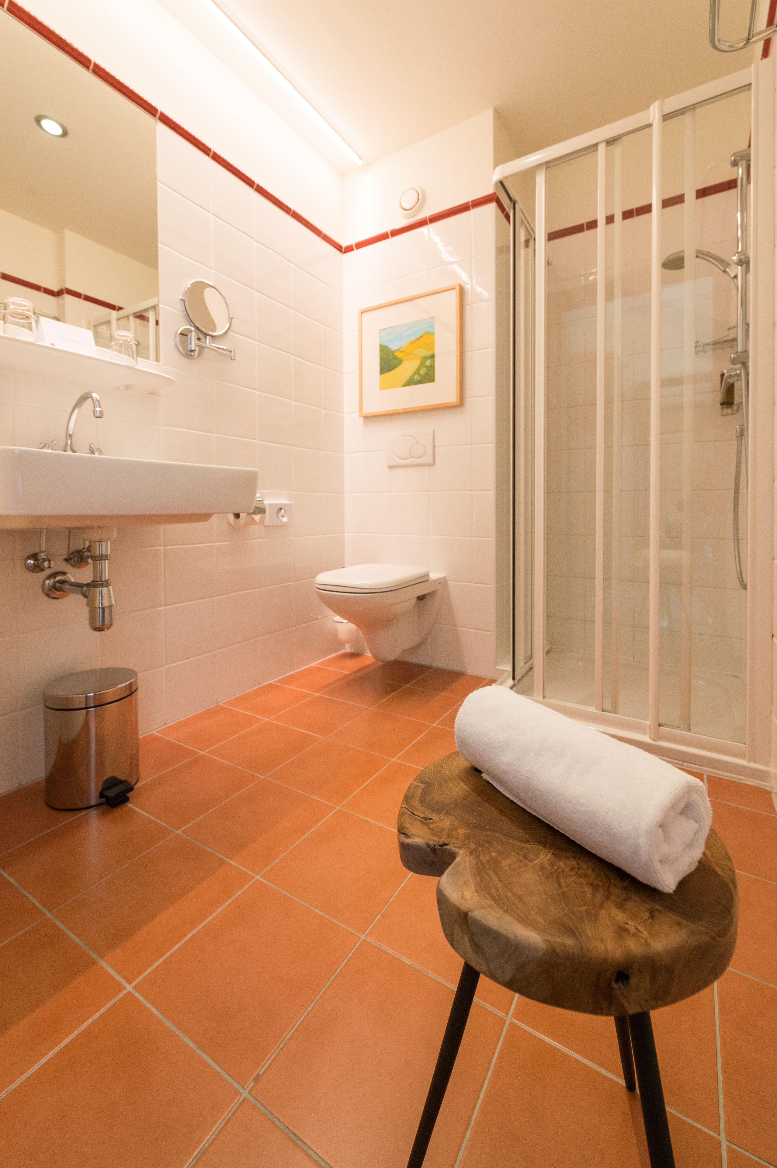 A bathroom with a sink, toilet, and glass shower enclosure.