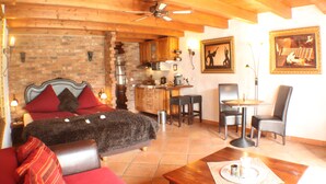 Una habitación con una cama, una mesa de comedor y una zona de cocina.
