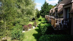 A row of cabins with a garden path leading through dense greenery. - Domaine de l'Arbrelle (Amboise)