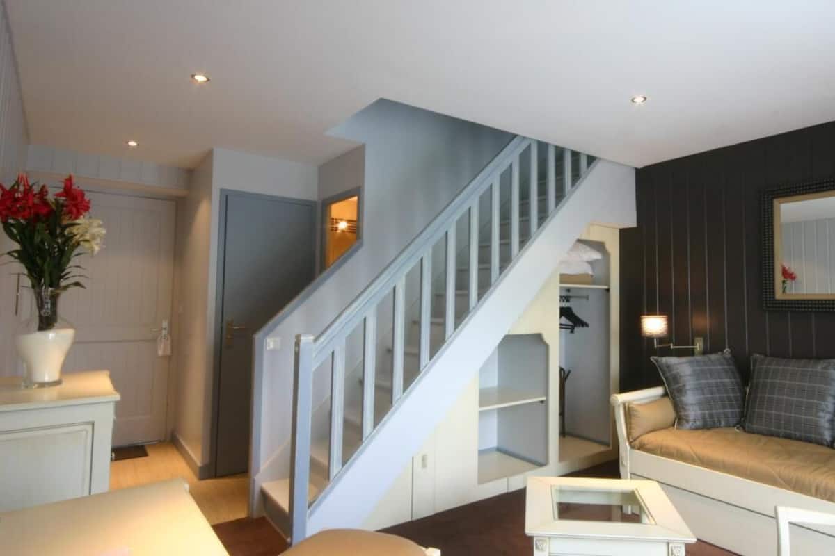 A modern living room with a staircase, a sofa, and a coffee table.