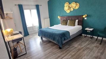 A modern bedroom with a large bed, a desk, and a chair.