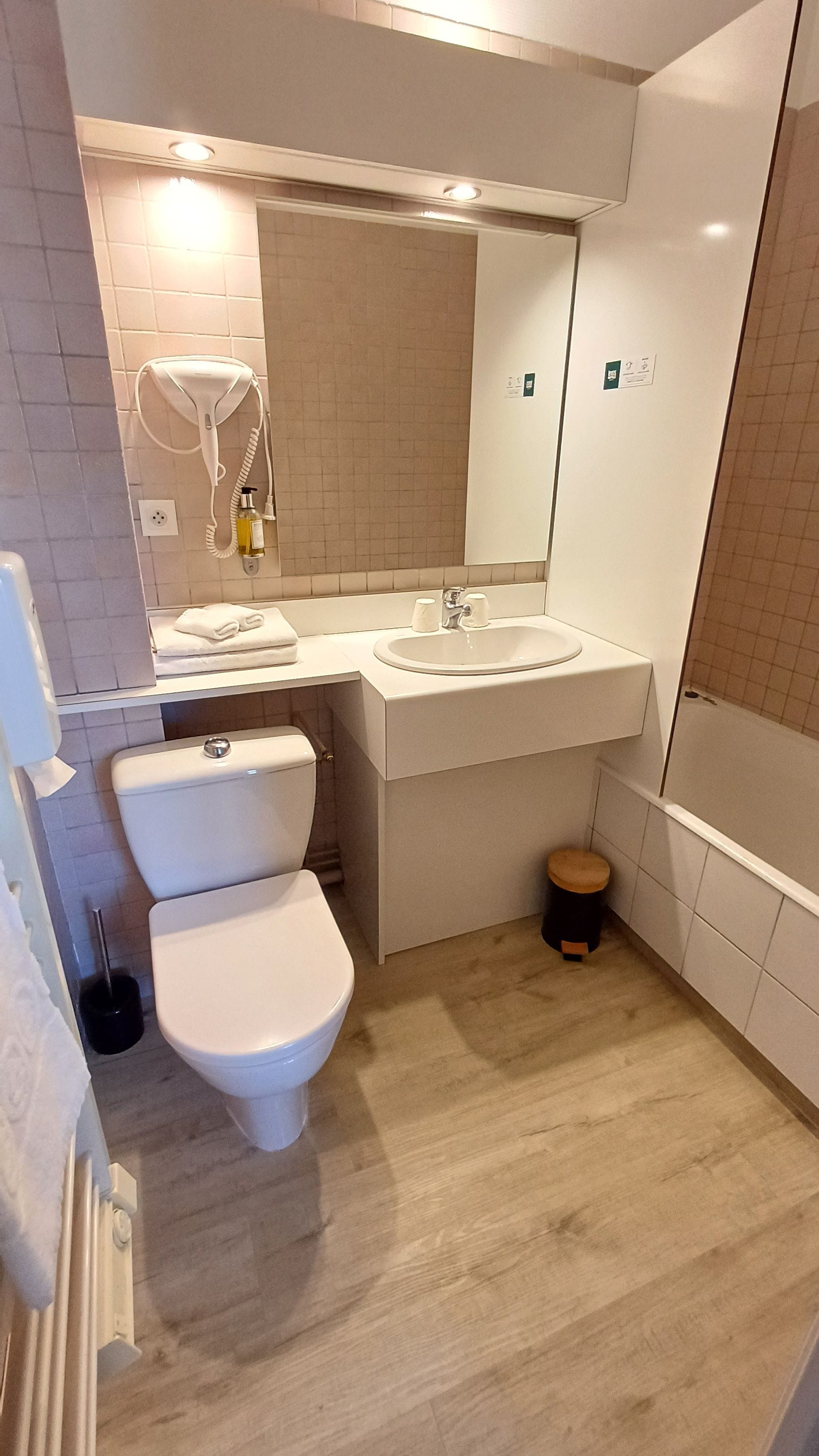 Een moderne badkamer met toilet, wastafel en spiegel.
