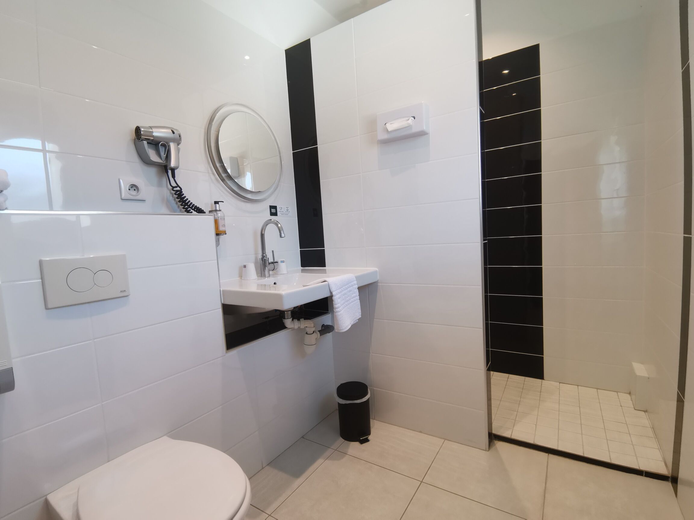 A modern bathroom with a toilet, sink, and shower area.