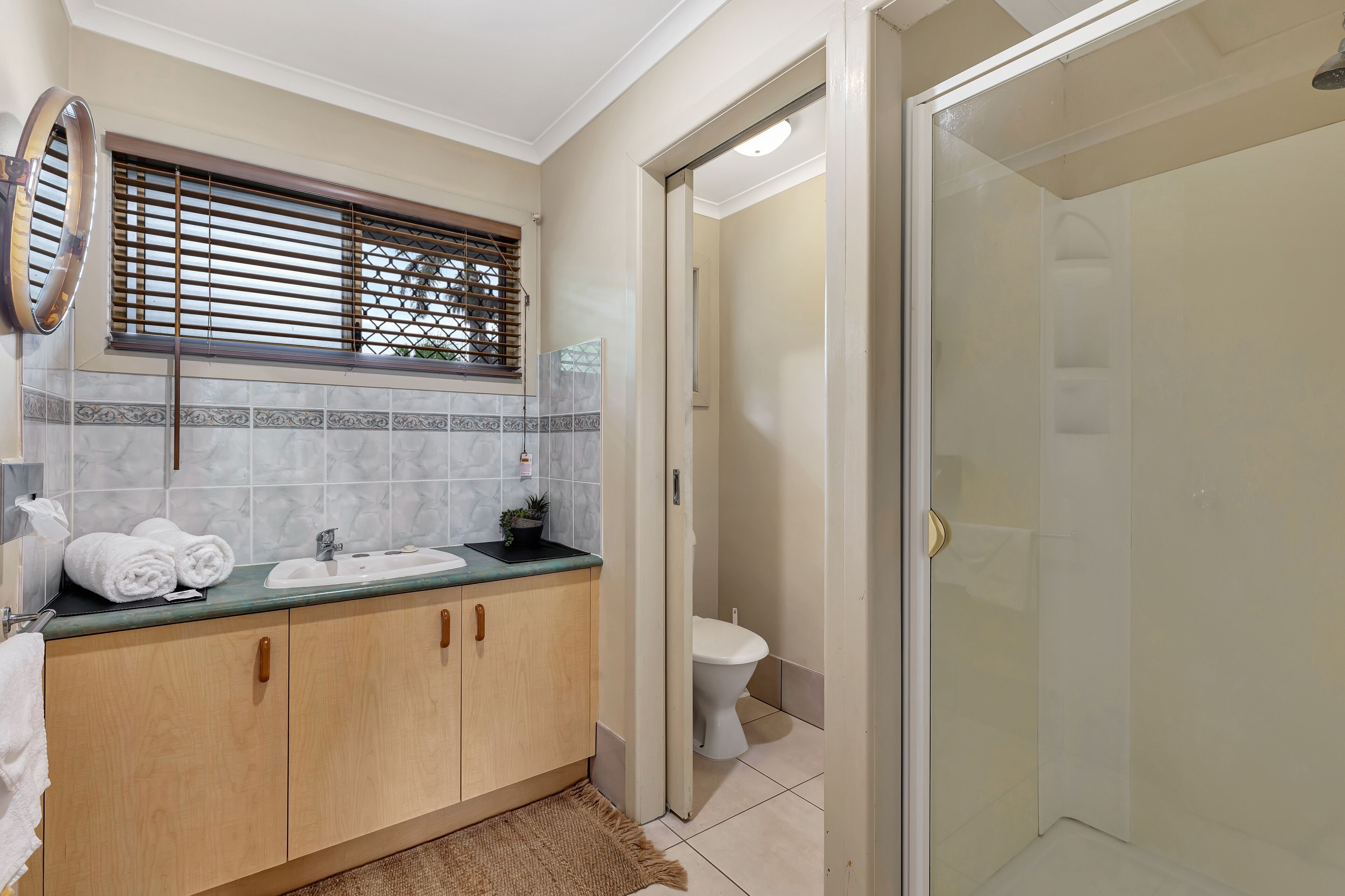 A bathroom with a sink, mirror, and toilet.