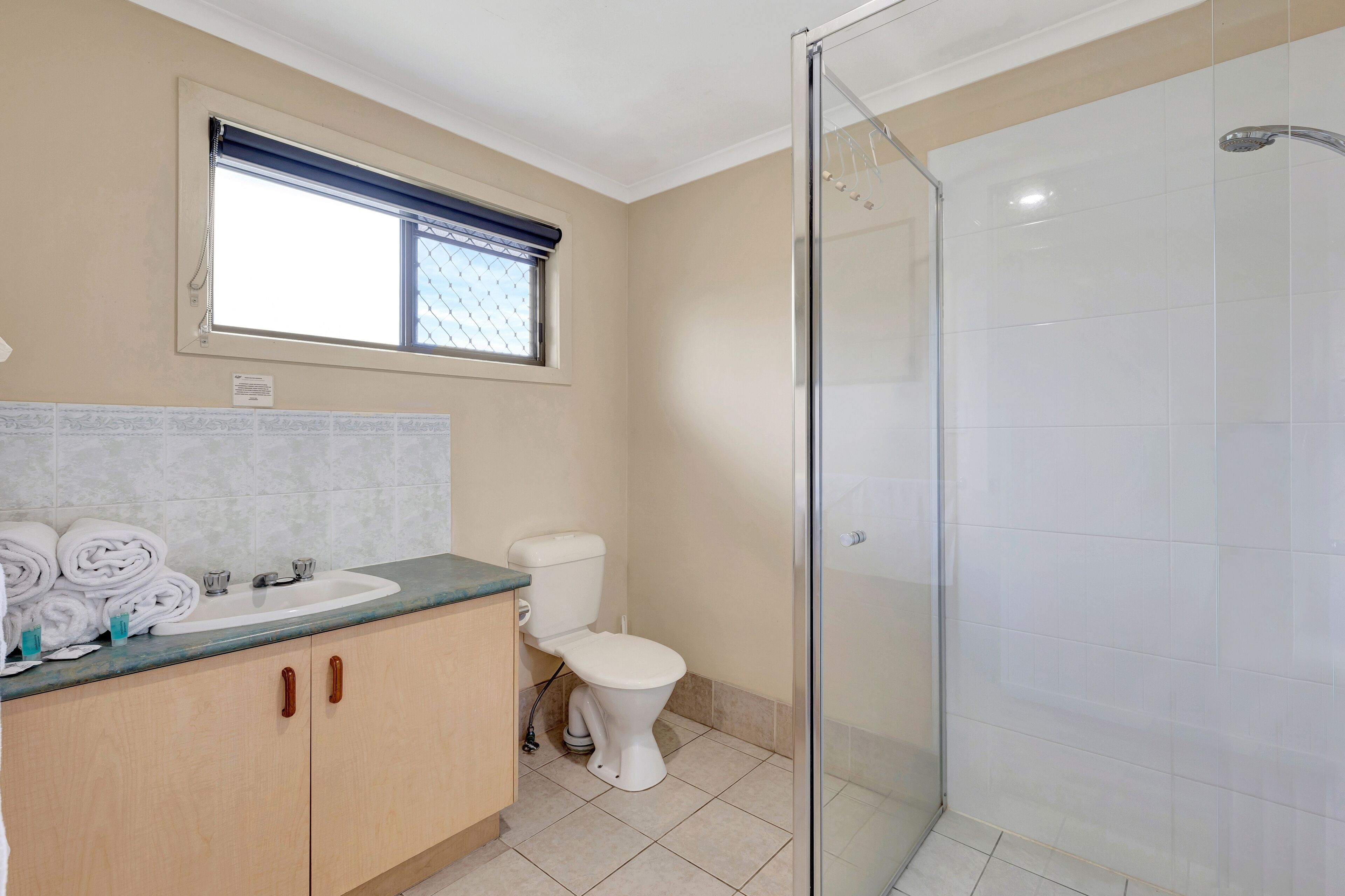 A bathroom with a sink, toilet, and shower.