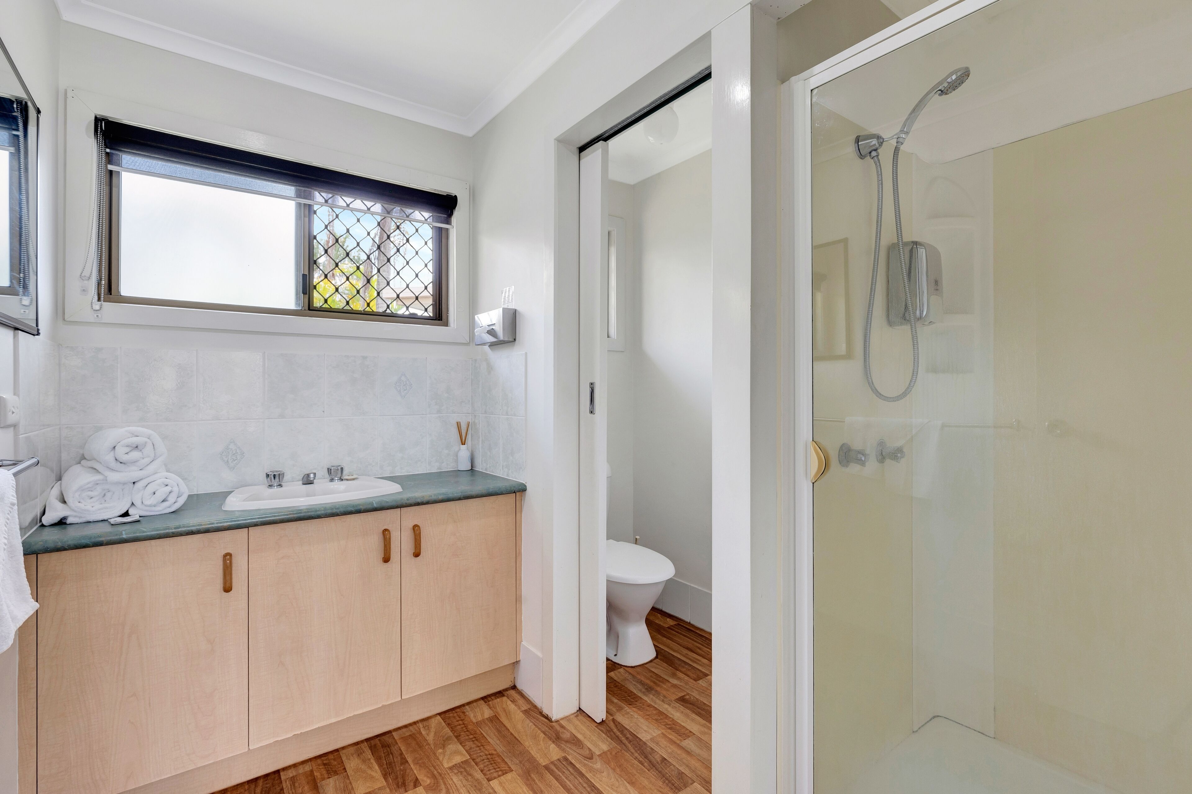 A bathroom with a sink, toilet, and shower.