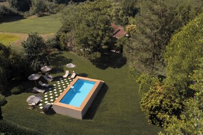 Una piscina al aire libre de temporada, sombrillas