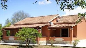 A two-story building with a tiled roof and a small garden area in front. - Erifili Apartments (Corfu)
