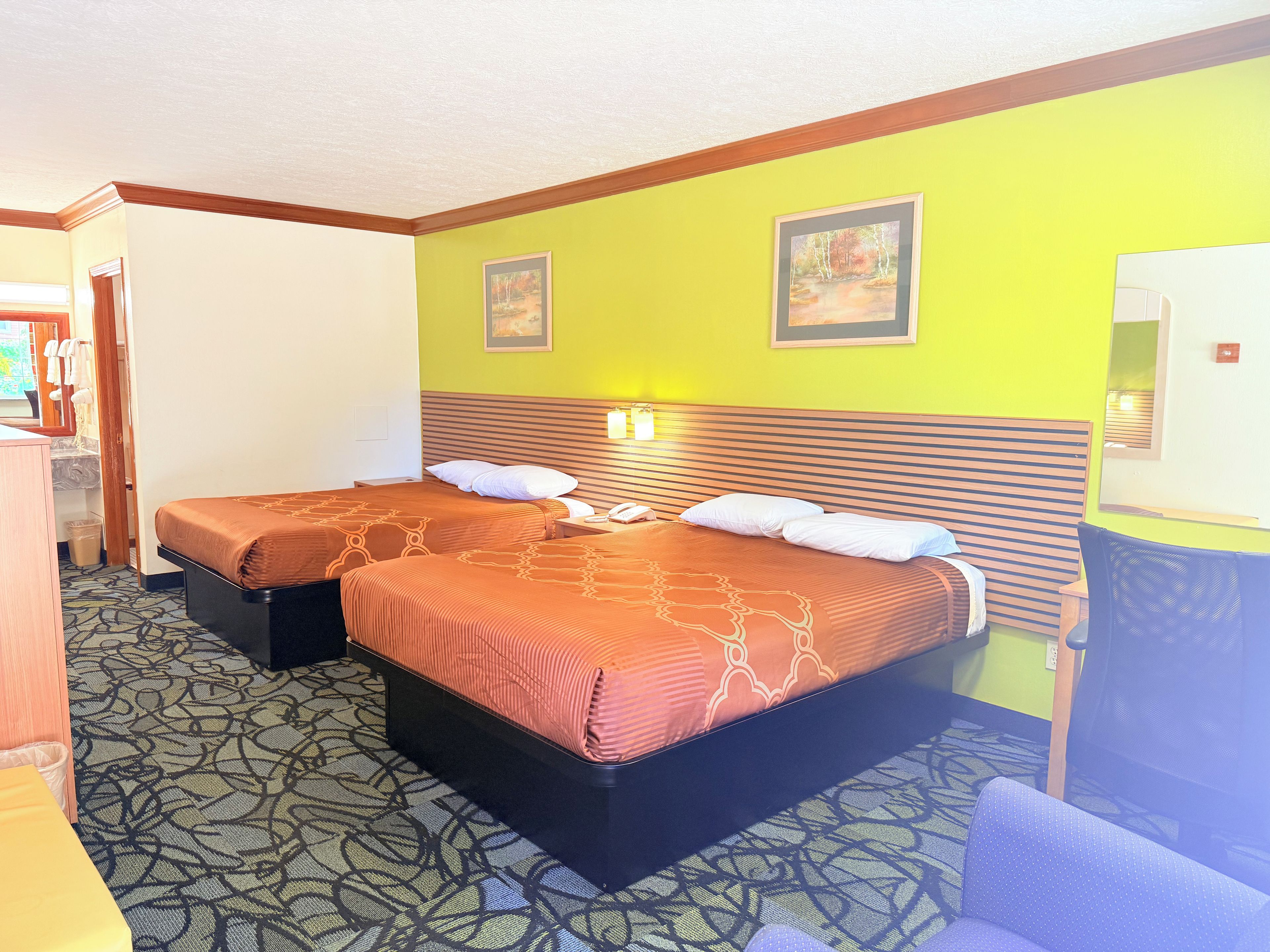 Una habitación de hotel con dos camas, un escritorio y una silla.