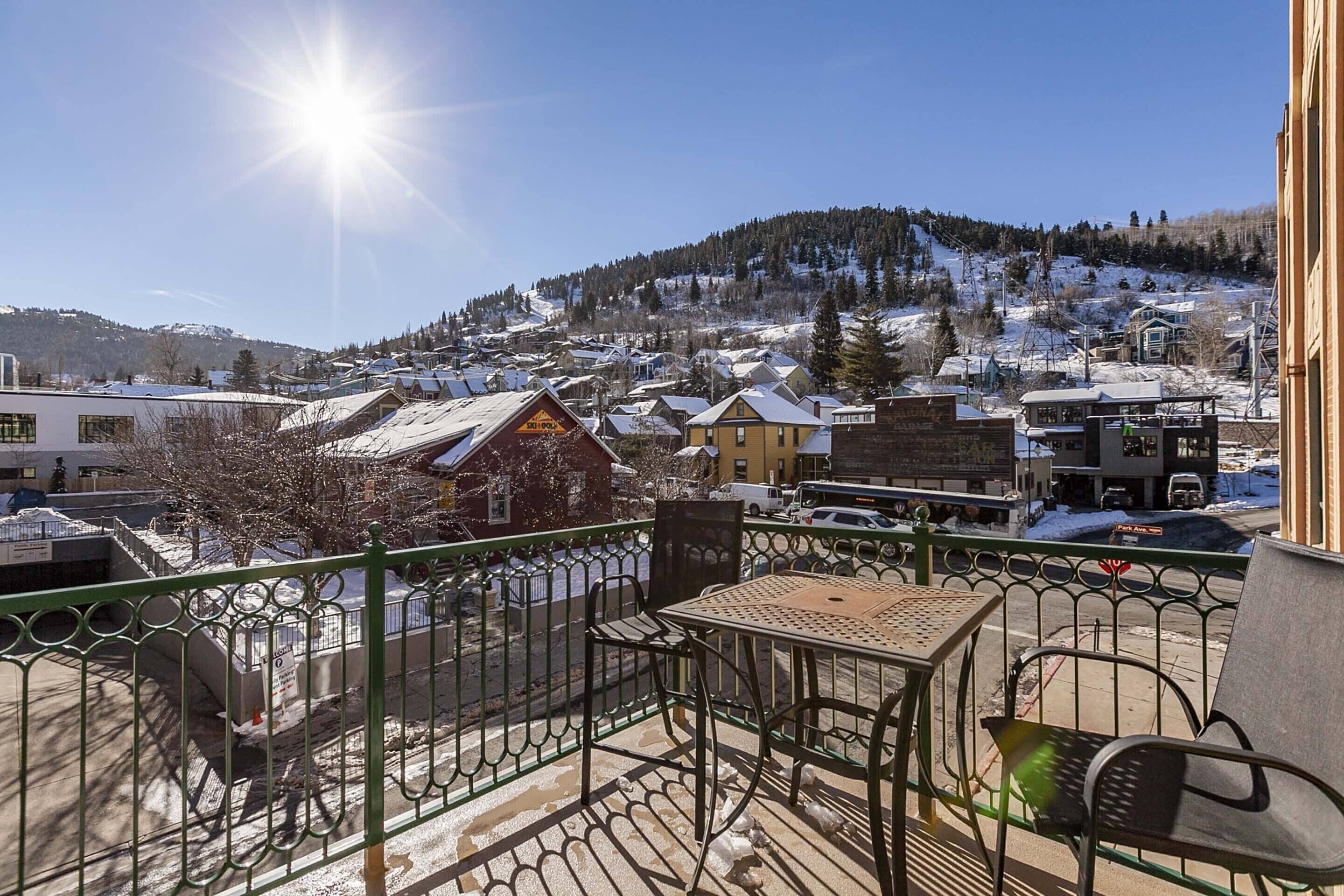 A balcony with a view of a snowy town and a mountain.