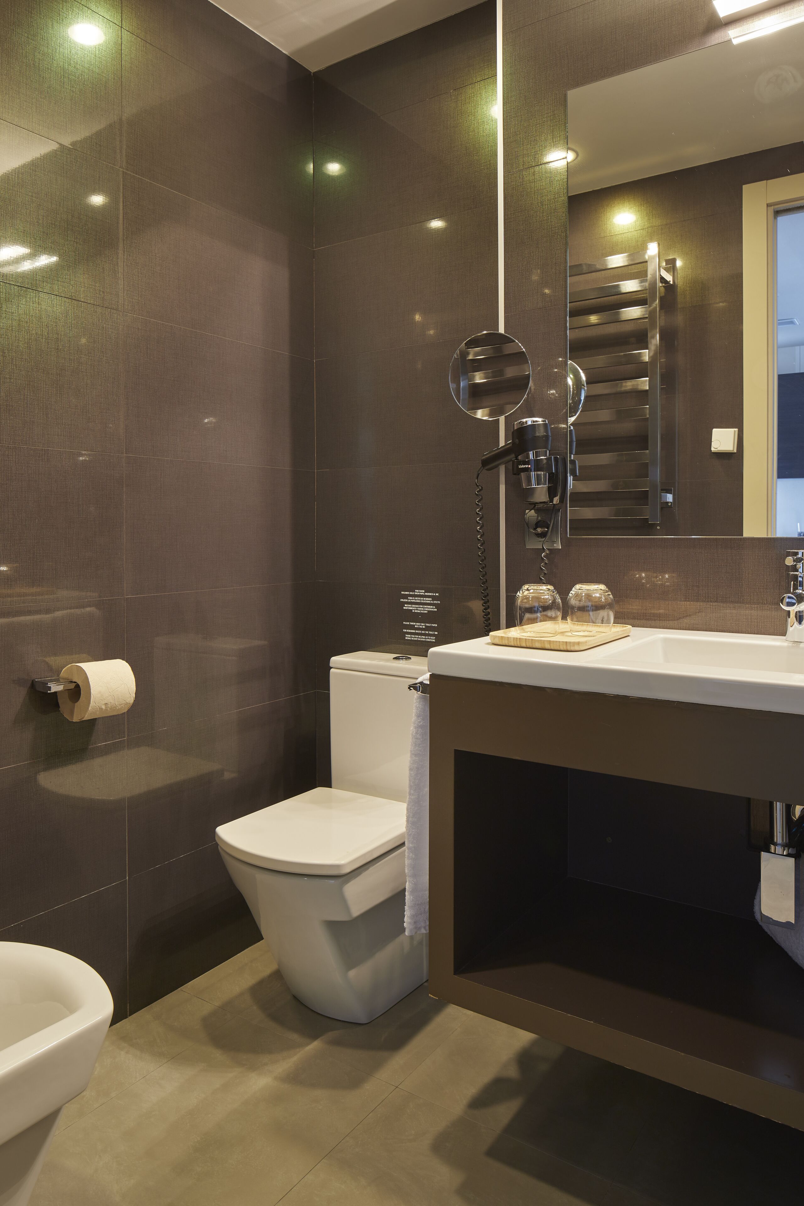 A modern bathroom with a toilet, sink, and mirror.