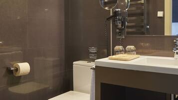 A modern bathroom with a toilet, sink, and mirror.
