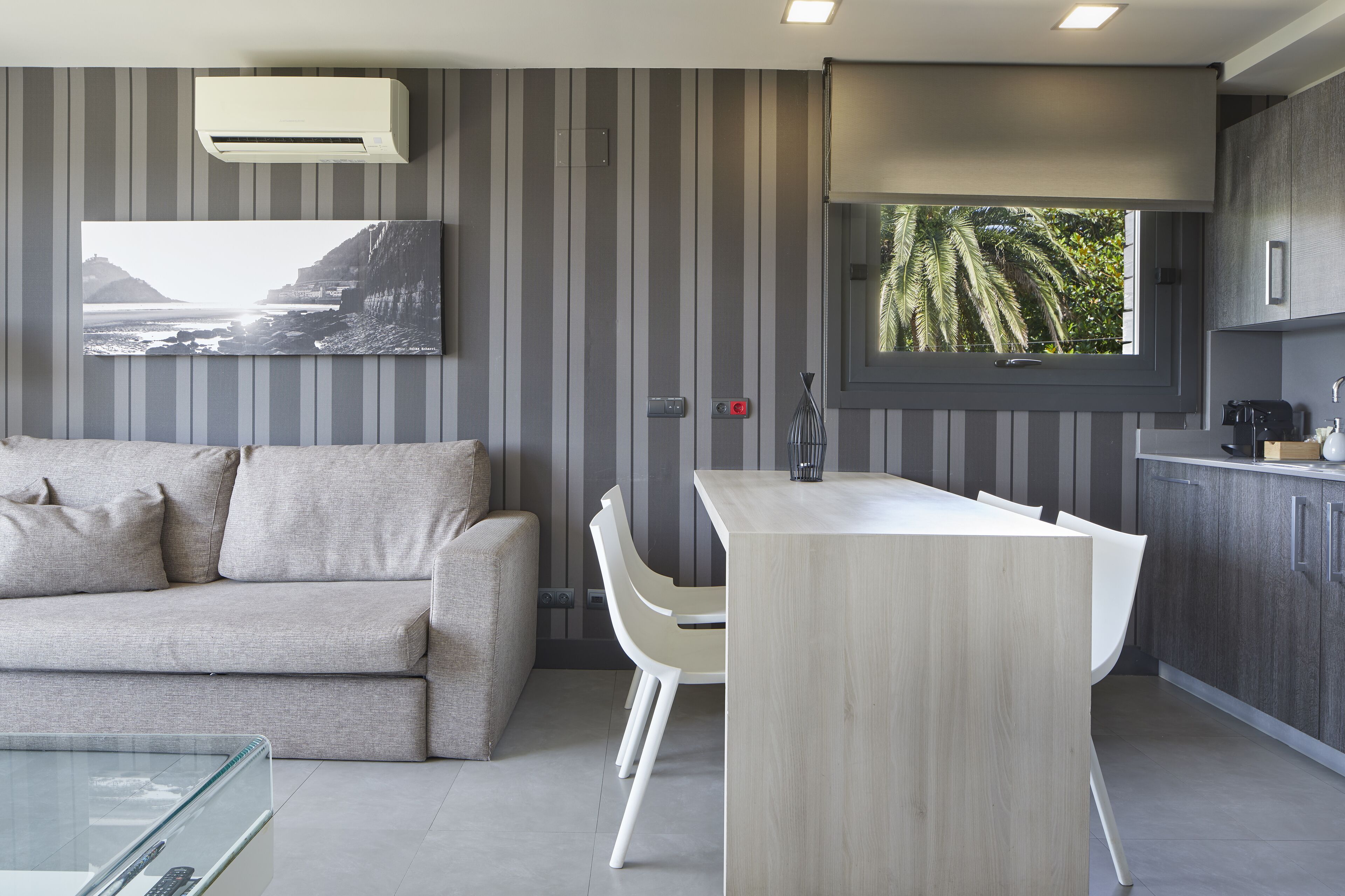 Una cocina moderna con comedor, un sofá y vistas al exterior.