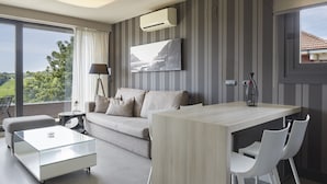 A modern living room with a sofa, a glass coffee table, a dining table with chairs, a lamp, and a painting on the wall. -  FeelFree STAYS Basoa (San Sebastián)
