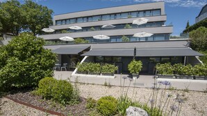 A modern building with multiple floors, outdoor seating, and potted plants. -  FeelFree STAYS Basoa (San Sebastián)