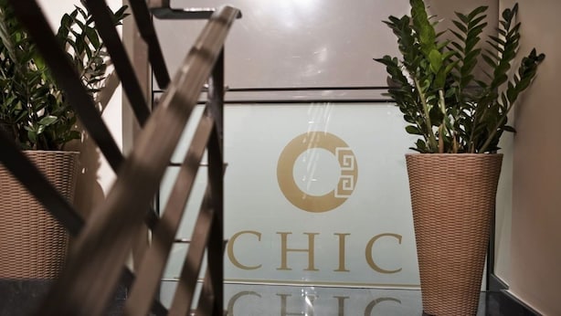 A sign with the word "CHIC" and a logo, flanked by potted plants. - Chic Hotel (Athens)