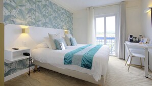 Une chambre d’hôtel avec un lit, un bureau et une vue sur l’extérieur.
