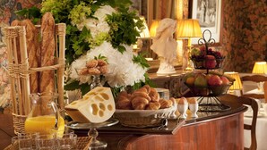 Een ontbijtbuffet met brood, gebak, kaas en fruit.
