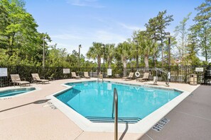 A swimming pool with lounge chairs and a fence. - Best Western Plus Westgate Inn & Suites (Leland)