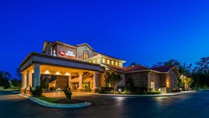 Un hotel Best Western Plus con una entrada amplia, un patio cubierto y un edificio de piedra adyacente.