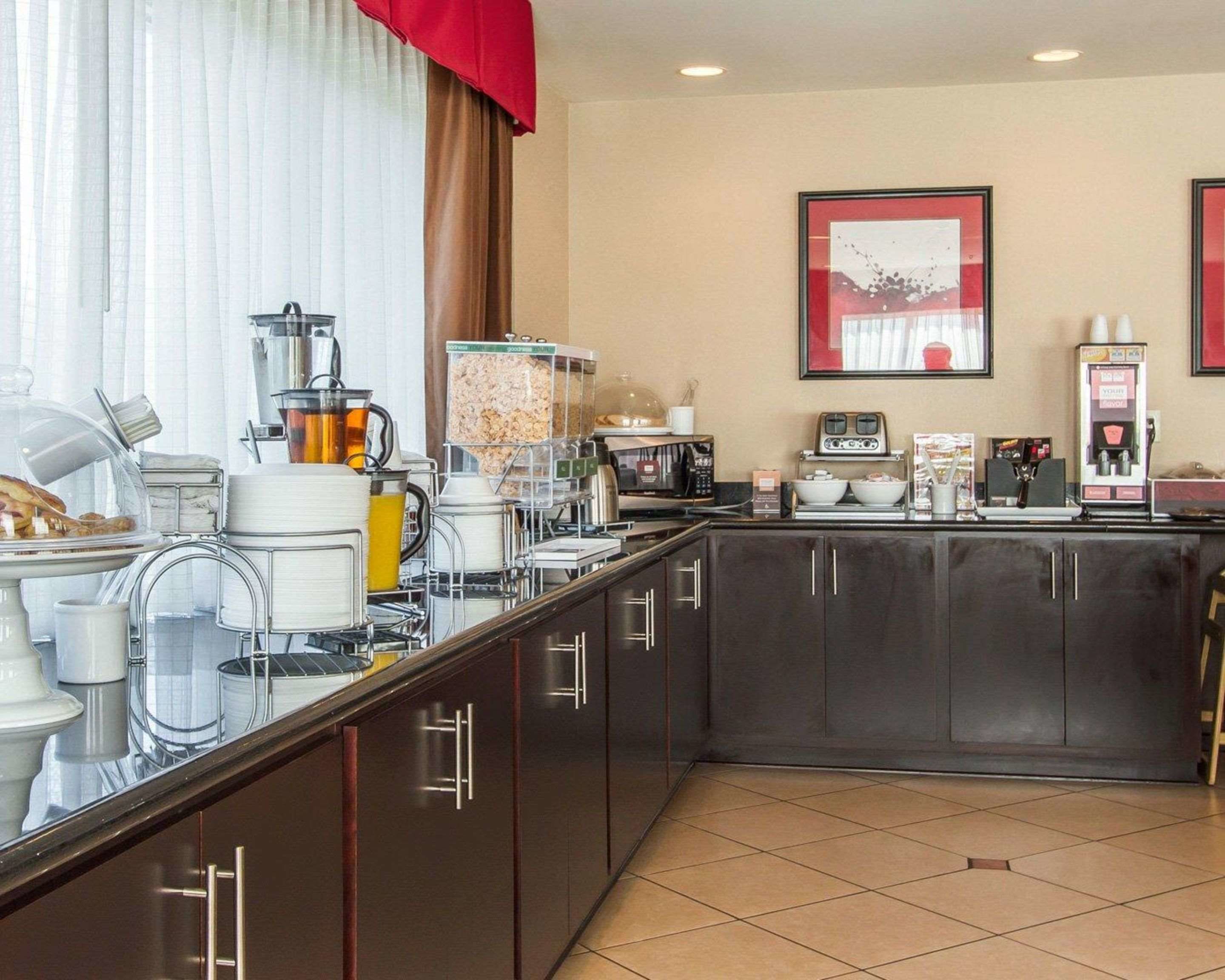 A modern kitchen with a breakfast bar, coffee machines, and a microwave.