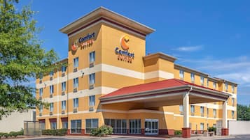Welcome to Comfort Suites, featuring a multi-story building with a covered entrance and ample parking.