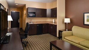 A hotel room with a kitchenette, a sofa, a desk, and a chair. - Holiday Inn Express Columbia by IHG (Columbia)