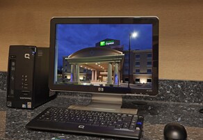 A hotel lobby with a large atrium, a reception desk, and a view of the building's exterior at night.