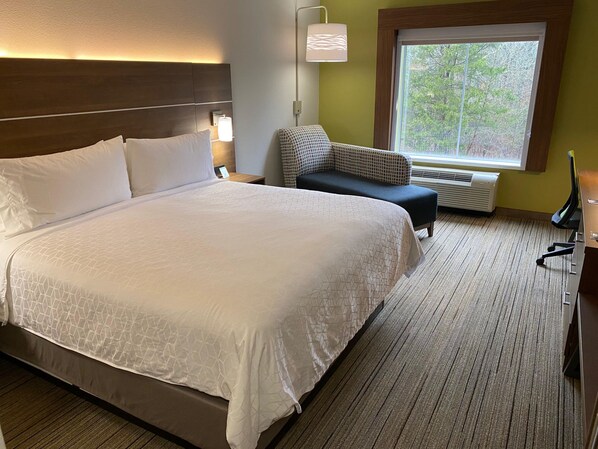 A hotel room with a large bed, a chair, a desk, and a window with a view of trees. - Holiday Inn Express Columbia by IHG (Columbia)