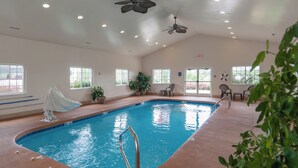 An indoor swimming pool with clear water, surrounded by potted plants, and equipped with a ceiling fan and recessed lighting. - Microtel Inn & Suites by Wyndham Princeton (Princeton)