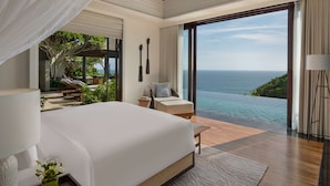 A spacious bedroom with a large bed, a view of the ocean, and a balcony with outdoor furniture. - Umana Bali, LXR Hotels & Resorts (Ungasan)