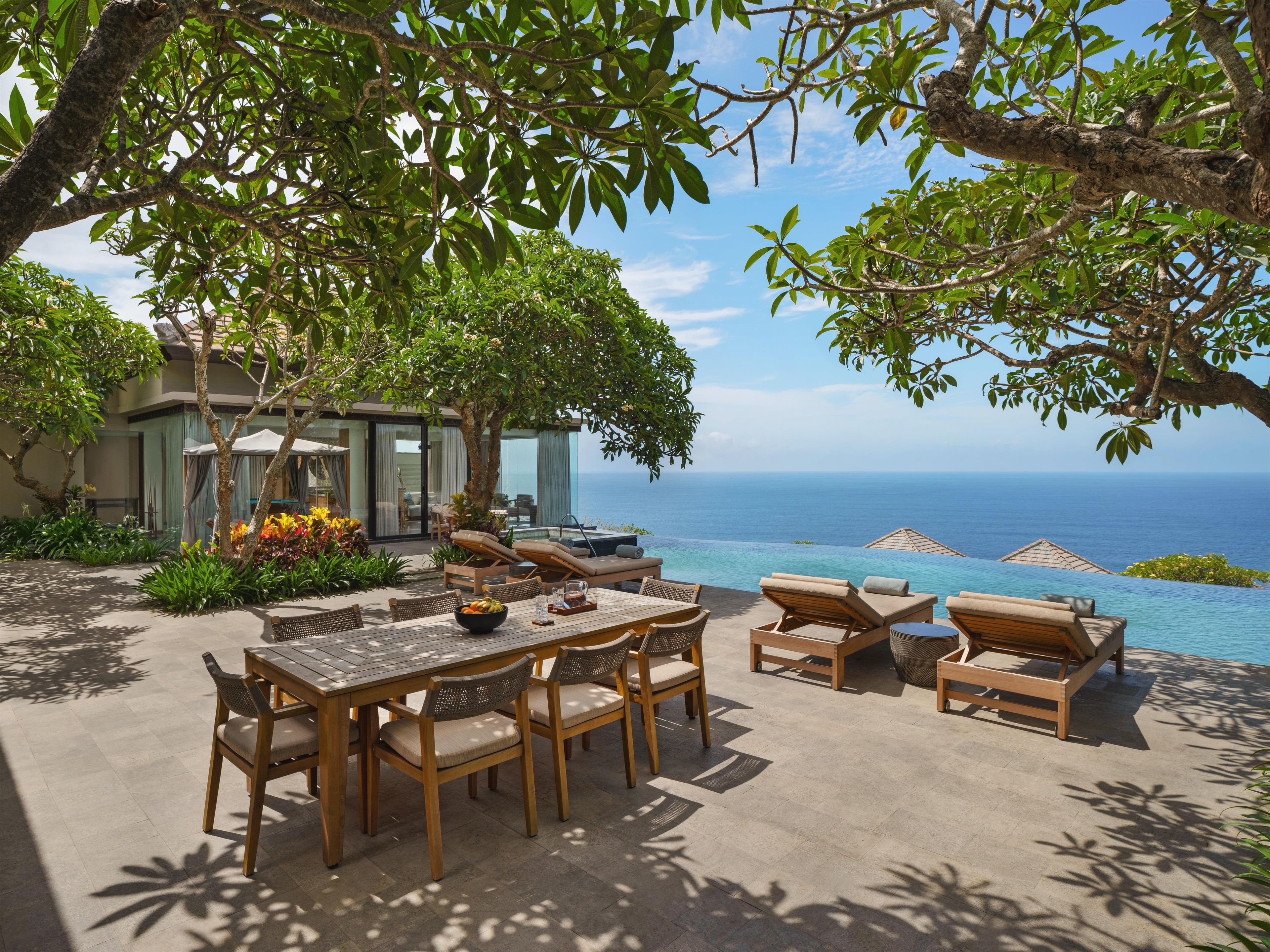 A luxurious outdoor seating area with a pool overlooking the ocean.