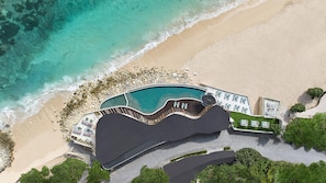 An aerial view of a resort with a swimming pool, beach, and landscaped areas. - Umana Bali, LXR Hotels & Resorts (Ungasan)